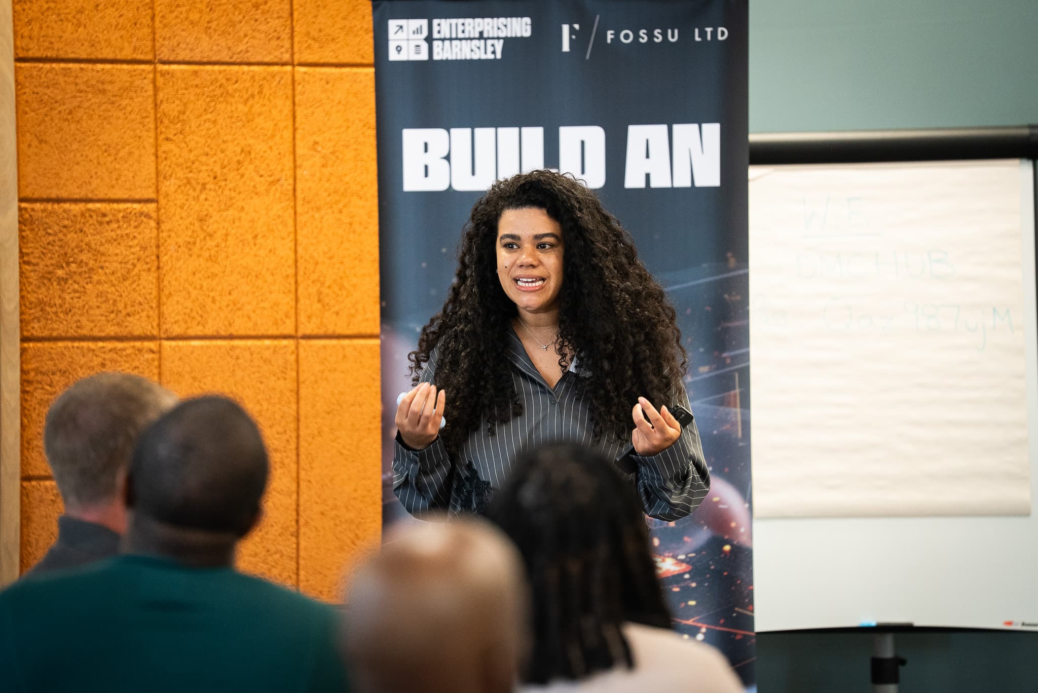 An Ignite AI trainer presenting to a room of business owners in front of the Ignite AI banner